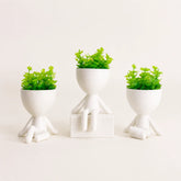 Kit com três mini vasos decorativos brancos e plantas artificiais