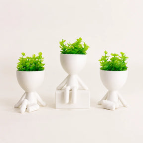 Kit com três mini vasos decorativos brancos e plantas artificiais