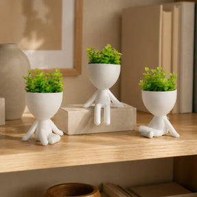Três mini vasos decorativos brancos com plantas artificiais em estante